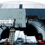 2016年中に建設工事を終え、チェルノブイリ原発3、4号炉（写真背後）を覆う予定となっているドーム（写真手前）。巨大事業のため計画は二転三転したが、フランスを中心とするヨーロッパの共同事業体NOVARKAによって進められている。写真はすべて、チェルノブイリ地区、ウクライナ。 2016年1月14日