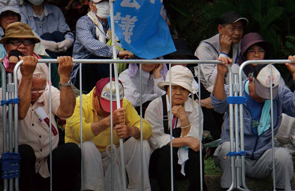 うるま市の女性殺害事件に抗議して、５月26日に嘉手納基地第一ゲート前でおこなわれた抗議集会。たった一人の女性の命さえ守れなかったという気持ちで打ちひしがれた屈辱感の中から、沖縄の全基地撤去を求める運動が大きく育っている。嘉手納基地第一ゲート前、2016年5月26日