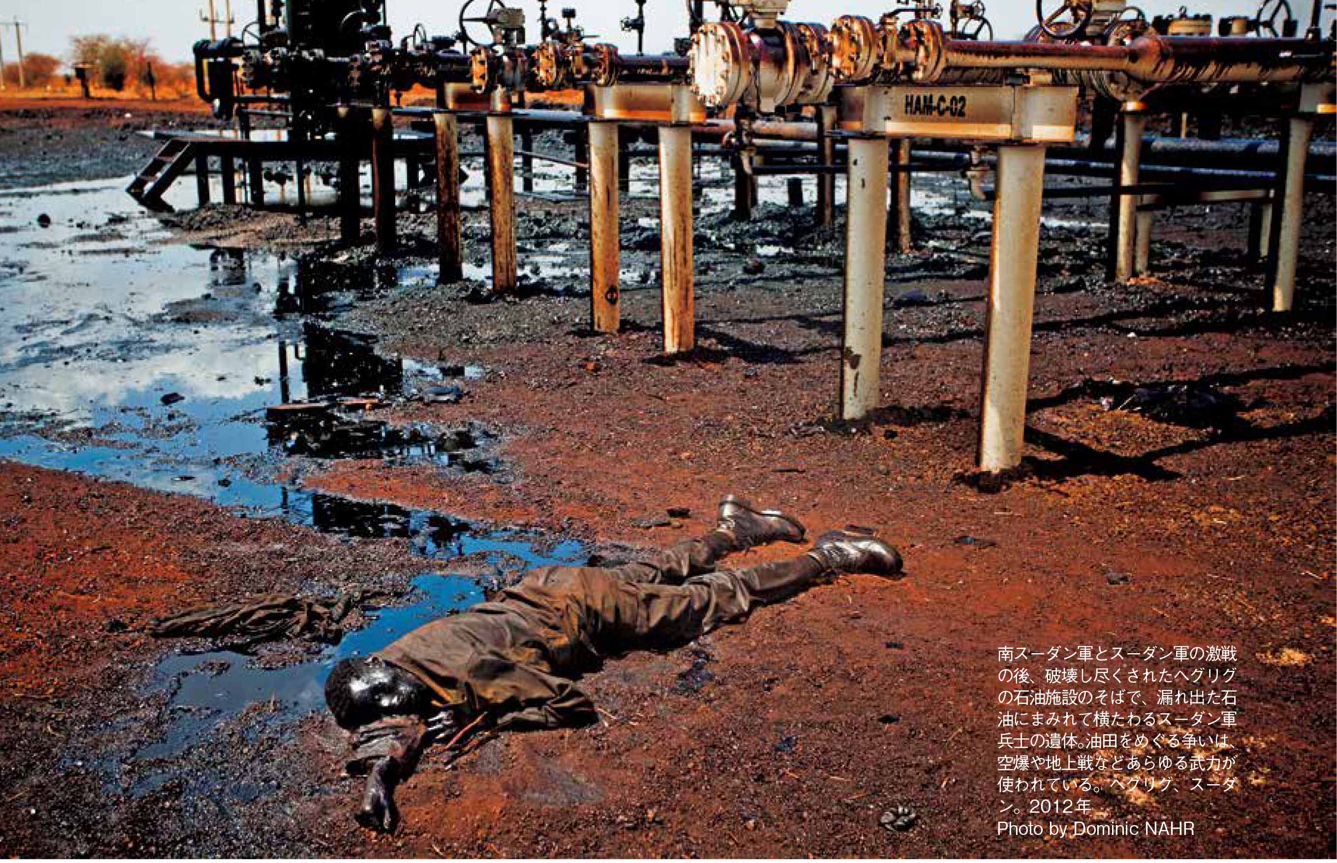 南スーダン軍とスーダン軍の激戦の後、破壊し尽くされたヘグリグの石油施設のそばで、漏れ出た石油にまみれて横たわるスーダン軍兵士の遺体。油田をめぐる争いは、空爆や地上戦などあらゆる武力が使われている。ヘグリグ、スーダン。2012年 Photo by Dominic NAHR