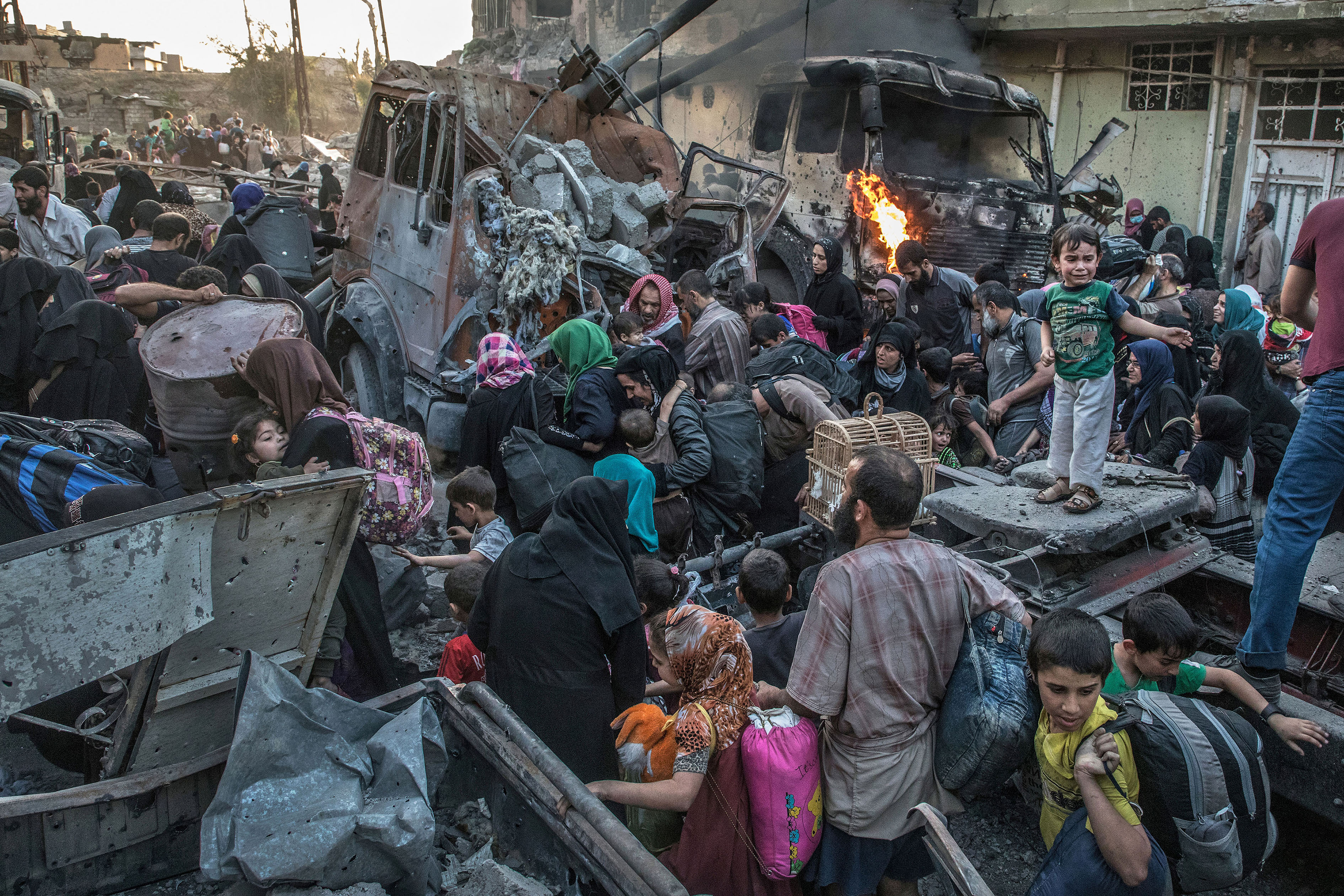 Mosul, Iraq, the 2nd of June, 2017 Hundreds of exhausted civilians in panic are fleeing Bab Sinjar, Zanjili and Abi Tamam, the 3 districts at the north of the old city still under control of IS. They cross the frontline during the battle to reach the Al Zahha district, released on the same day by the iraqi special forces. Photo Laurent Van der Stockt for Le Monde / Getty Reportages Mossoul, Irak, le 02/06/2017 Des centaines de civils épuisés fuient en panique Bab Sinjar, Zingjili et Abi Tamam, des quartiers de Mossoul encore aux mains de Daesh. Ils traversent la ligne de front dans le fracas des bombes et des échanges de tirs nourris pour rejoindre le quartier de Al Zahha, qui est en train de passer sous contrôle des forces spéciales irakiennes. Photo Laurent Van der Stockt pour Le Monde